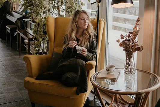 Woman Eating Yogurt and Looking Out the Window